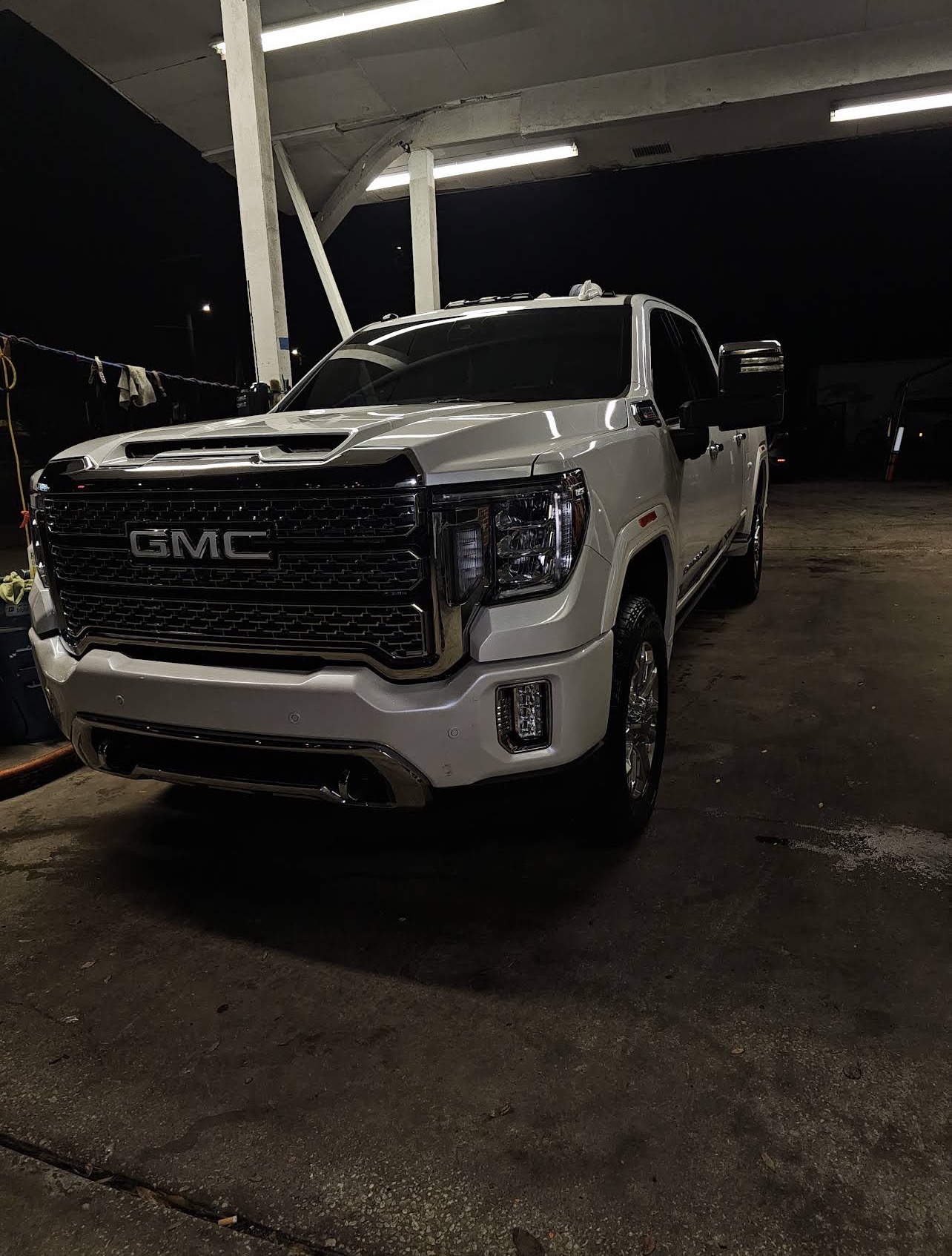 White GMC Denali HD with a deep reflective ceramic-coated finish under shop lighting