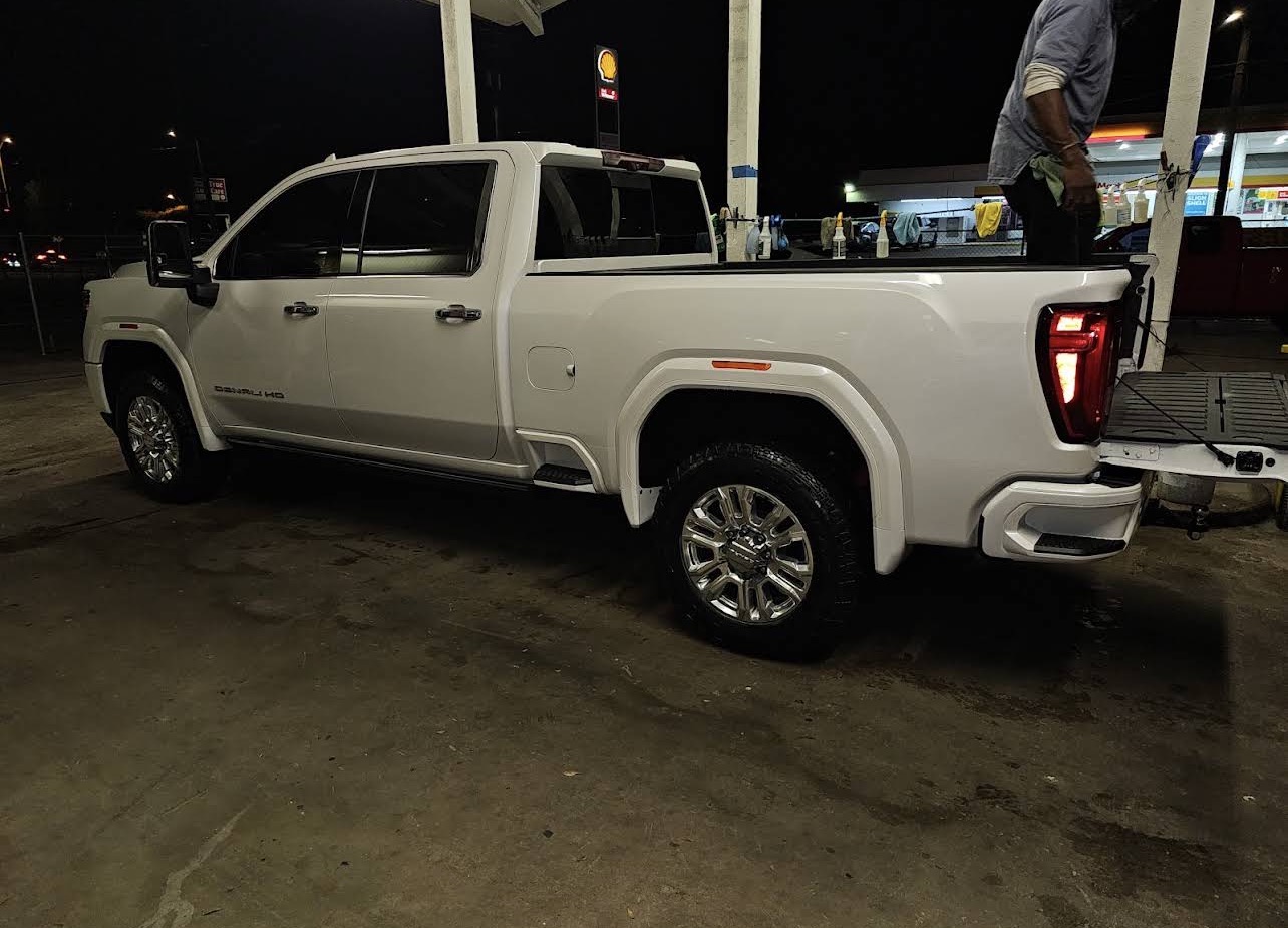 Side profile of a white GMC Sierra Denali with corrected, swirl-free paint