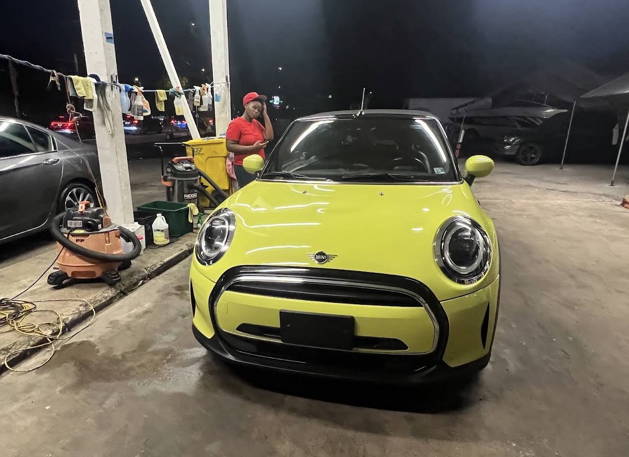 Bright green MINI Cooper being detailed at the shop in the evening